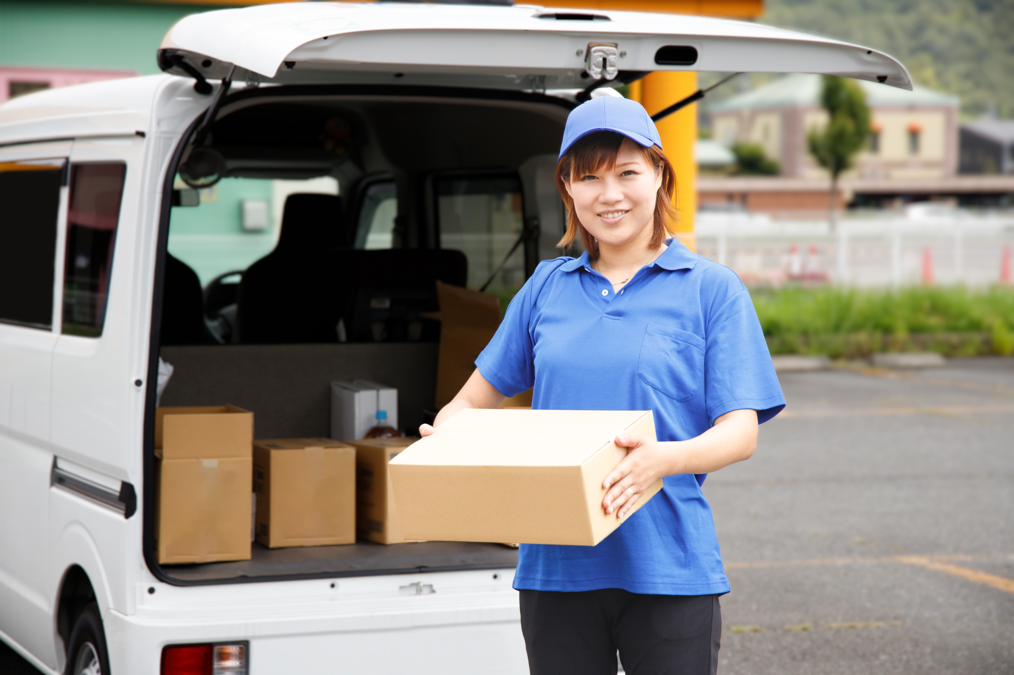 荷物の積み下ろしをする軽貨物ドライバーの女